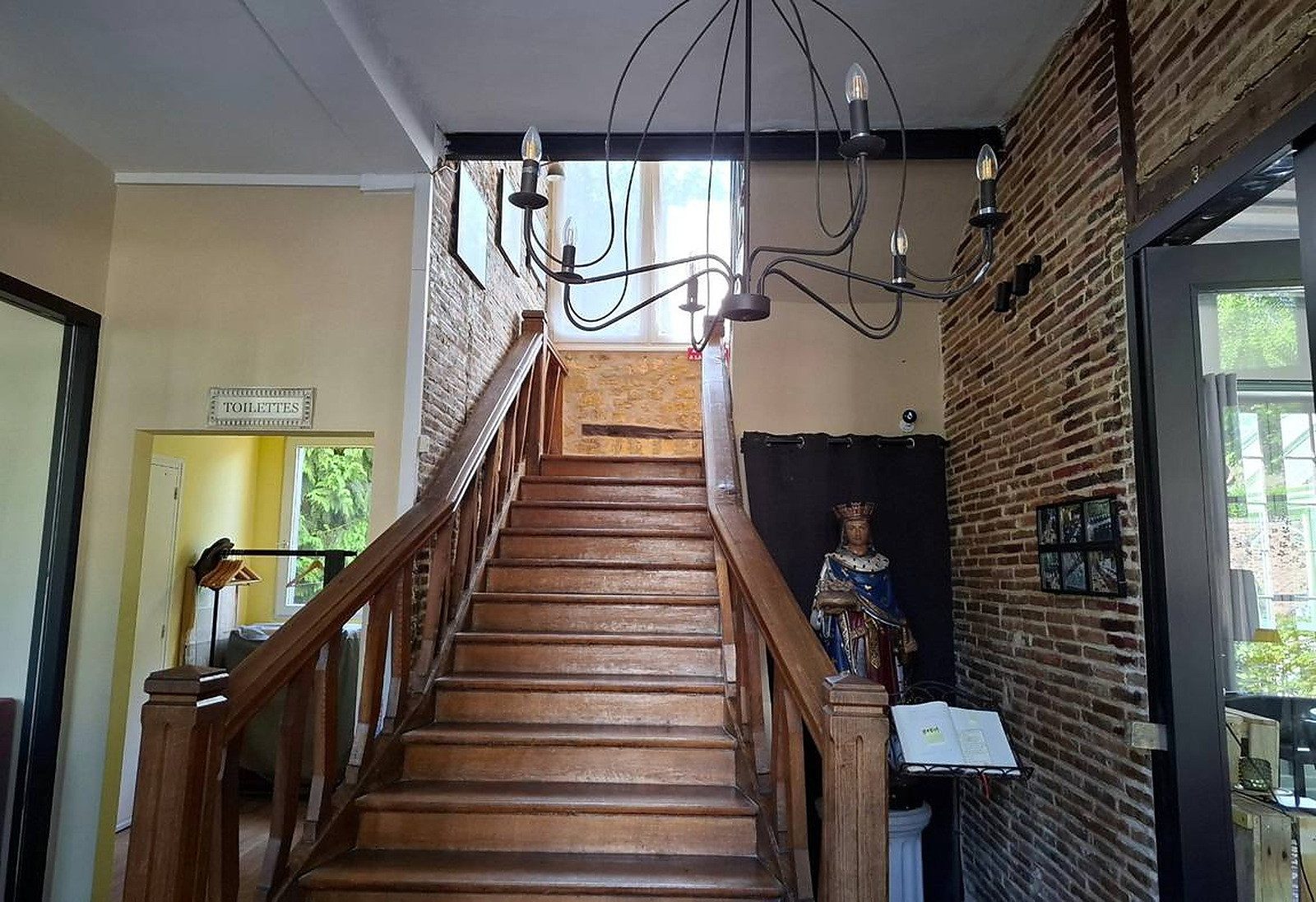 Grand escalier de bois et statue de Saint Louis dans le hall de l'hôtel à Bellême